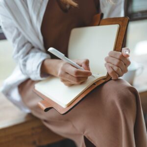 Frau schreibt in ein leeres Journal